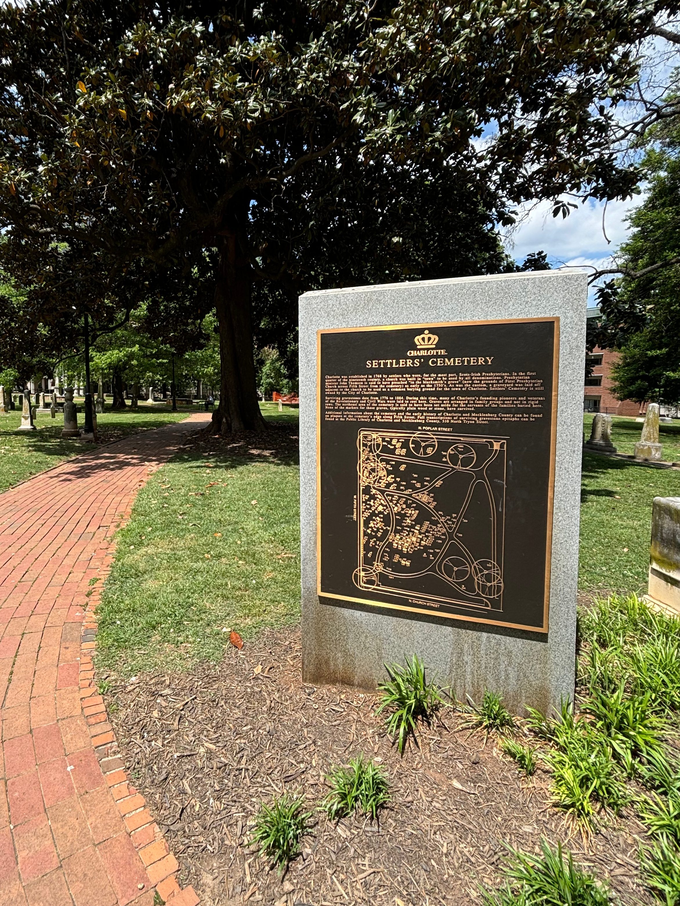 A bronze plaque welcomes visitors to the Settler's Cemetery with a map of the site and a brief history